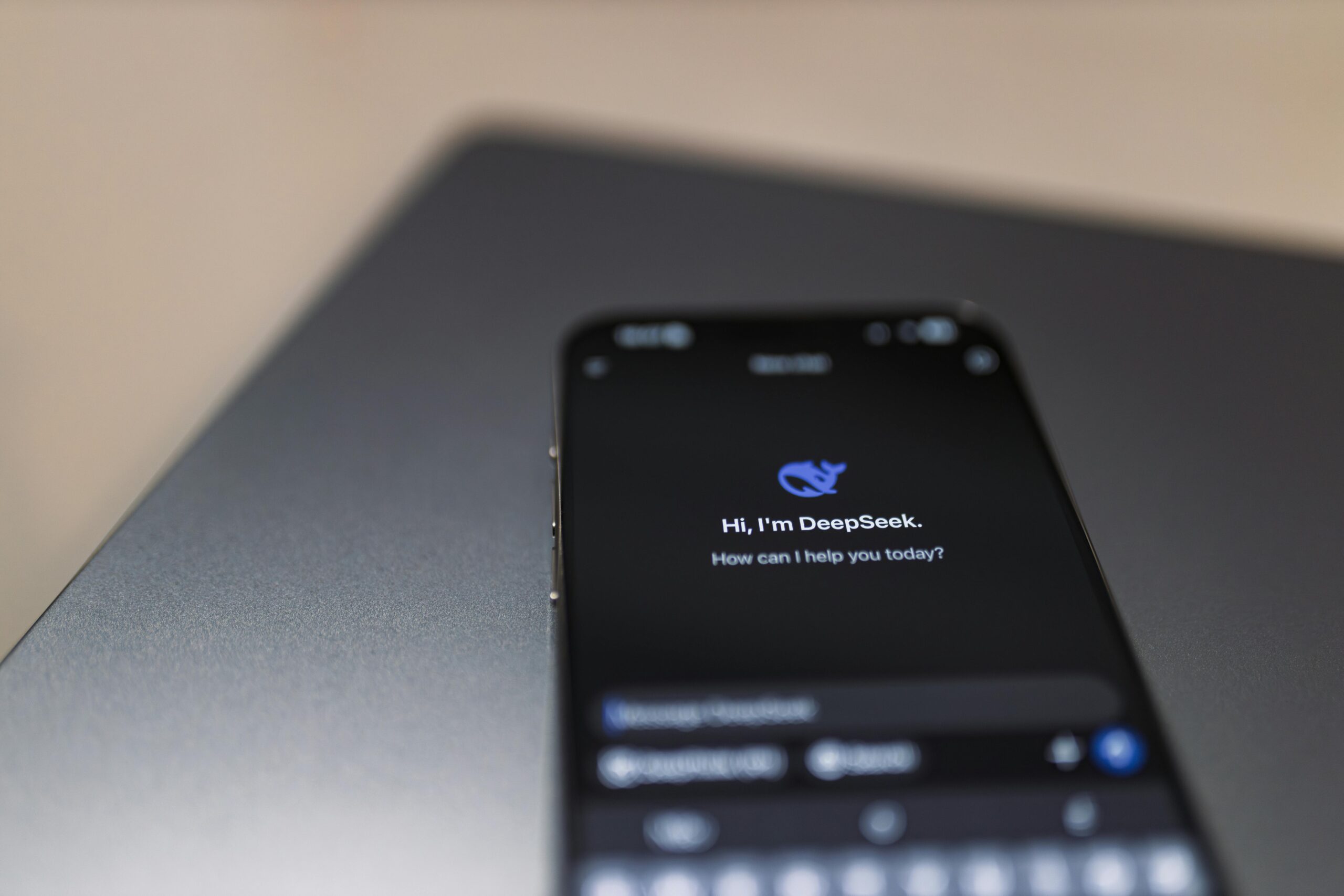 Reels skalieren: ChatGPT‑Prompts, Workflow & Automation 2 Nahaufnahme eines Smartphones mit KI-Assistentenschnittstelle auf dem Bildschirm über einem Laptop.
